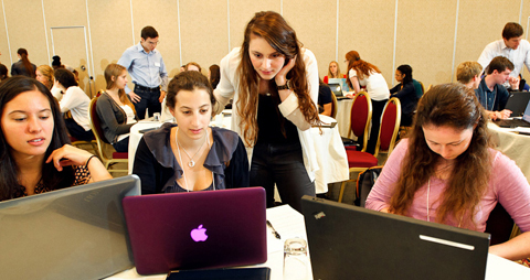 Peer advisor Lisa Labate '14, standing, assists (L to R) Catherine Luciani '15, Rebecca Hillel '15 and Elizabeth Buchanan '15 in an exercise during Sophomore JumpStart.