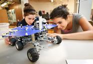 Emily Winter '14 (left) and Rose Berns-Zieve '15, admire a LEGO replica model of the Mars Rover at the Children's Museum in Utica during a visit by Outreach Adventure students.