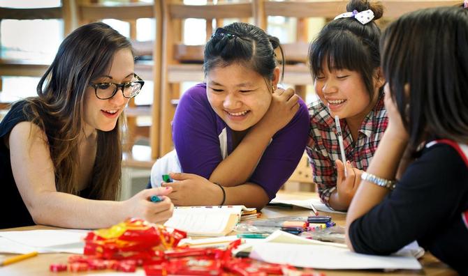 Maggie Haag '15, left, teaches English to refugees at Conkling School in Utica.