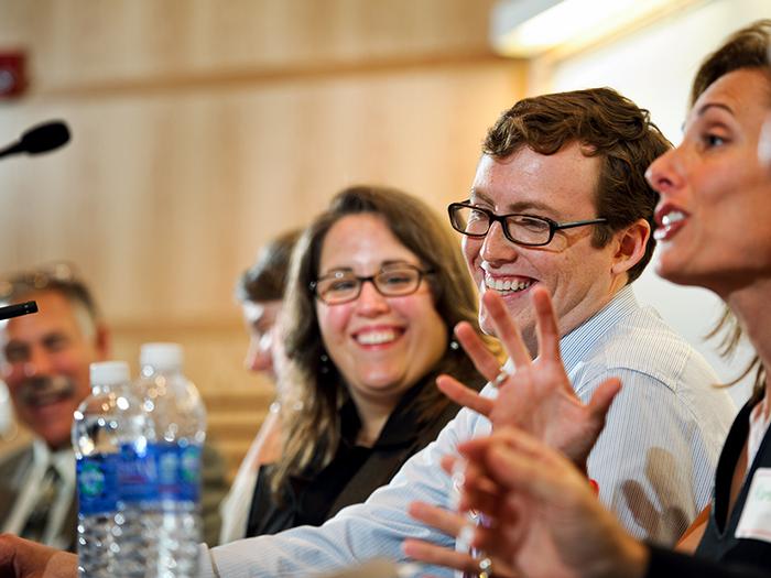 Professor of Biology Herm Lehman, Alysia Mihalakos '01 and James Liebow '13 listen to Karen McDonnell '91 make comments during a panel on Public Health Context and Challenges.