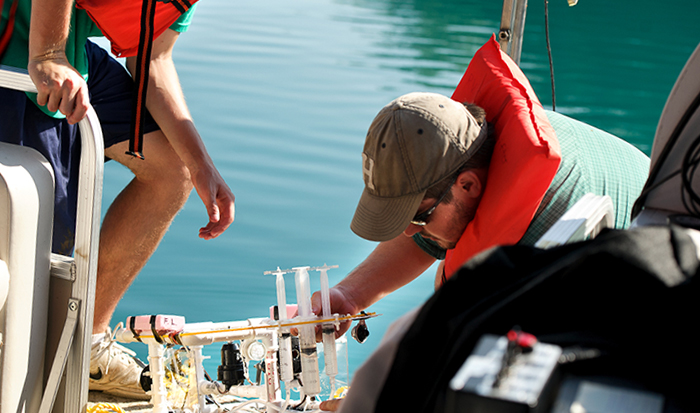 Rob Clayton, left, and Daniel Lichtenauer, remove a sample syringe containing bacteria samples from Green Lake. PHOTO: BY NANCY L. FORD