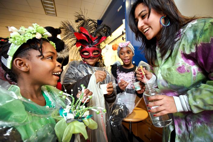 Jeanette Parra '16 makes slime for children in the science lab during Trust Treat. PHOTO: BY NANCY L. FORD