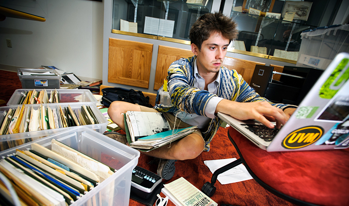Will Newman '14 sorts and organizes a large cache of materials by the late poet Agha Shahid Ali in Burke Library's Special Collections.
