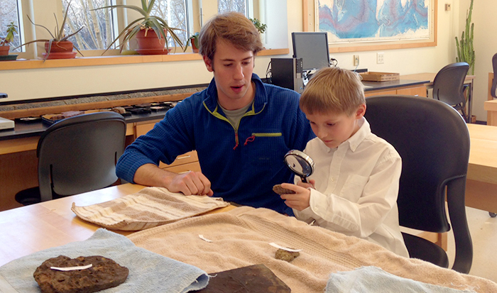 Colyer Woolston '14 and Clinton first grader John Musante examine fossils in the lab.