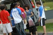 Orientation leaders help a first-year student move in.