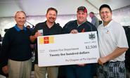 Jack Withiam '71, Pat Murphy '80, Chief Mark Young of the Clinton Fire Department and Pat Gilrane '83 pose with a ceremonial check representing Psi U's donation to CFD.