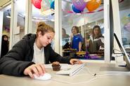 With a party going on behind her, Kayla Winters '13 works with a cupcake at hand, during a birthday celebration for the Writing Center.