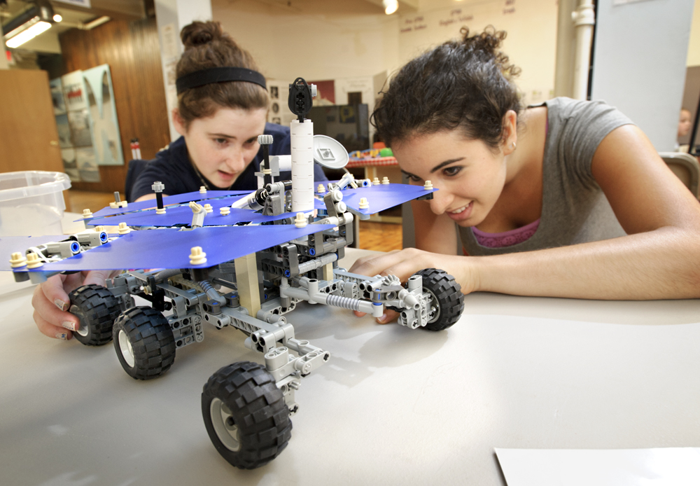 Emily Winter '14 (left) and Rose Berns-Zieve '15, admire a LEGO replica model of the Mars Rover at the Children's Museum in Utica during a visit by Outreach Adventure students.