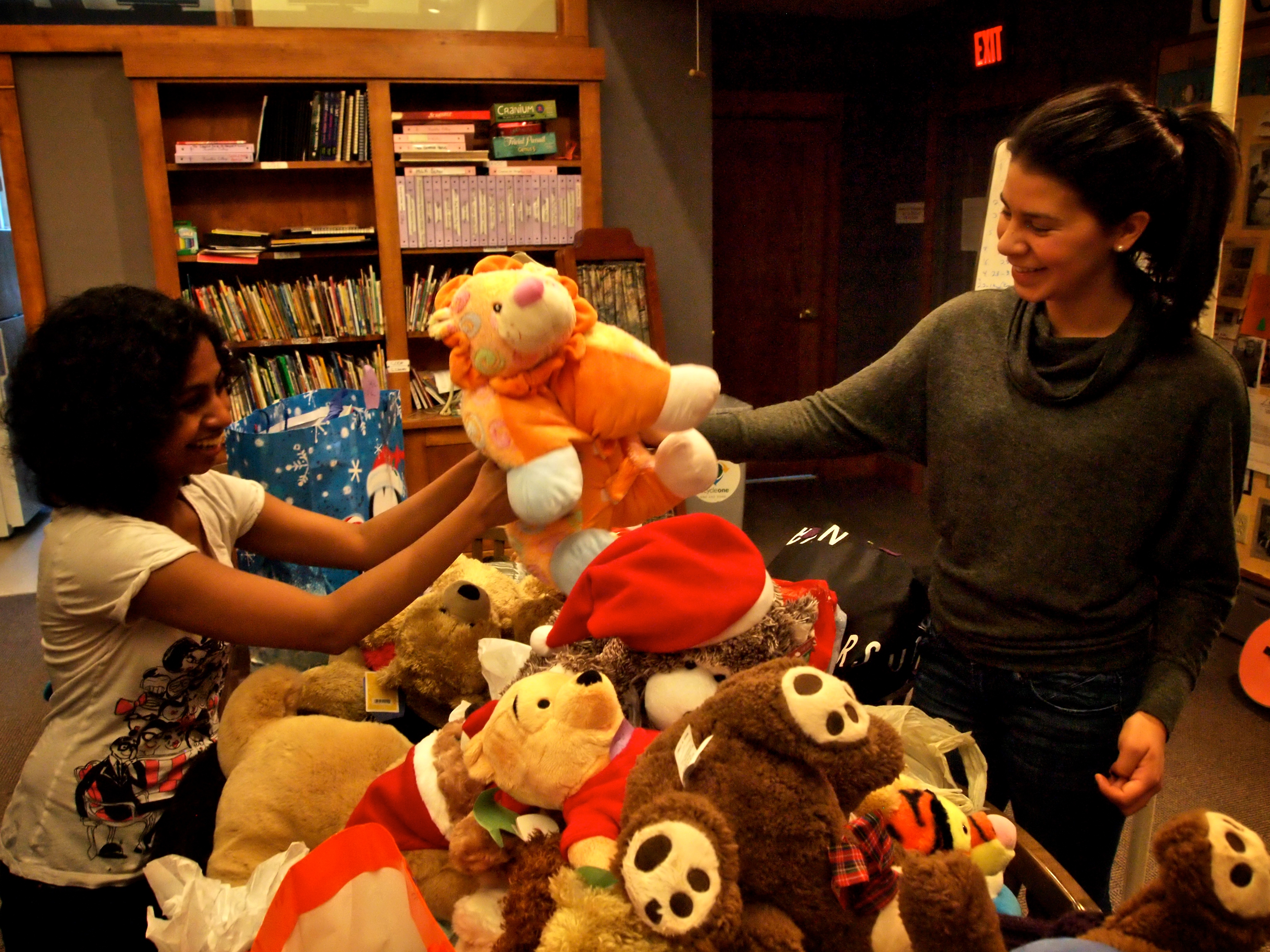 COOP Senior Fellow Ramya Ramnath '13, left, helps Elizabeth Rodriguez '15, Mitten Tree coordinator, with some of the toys collected.