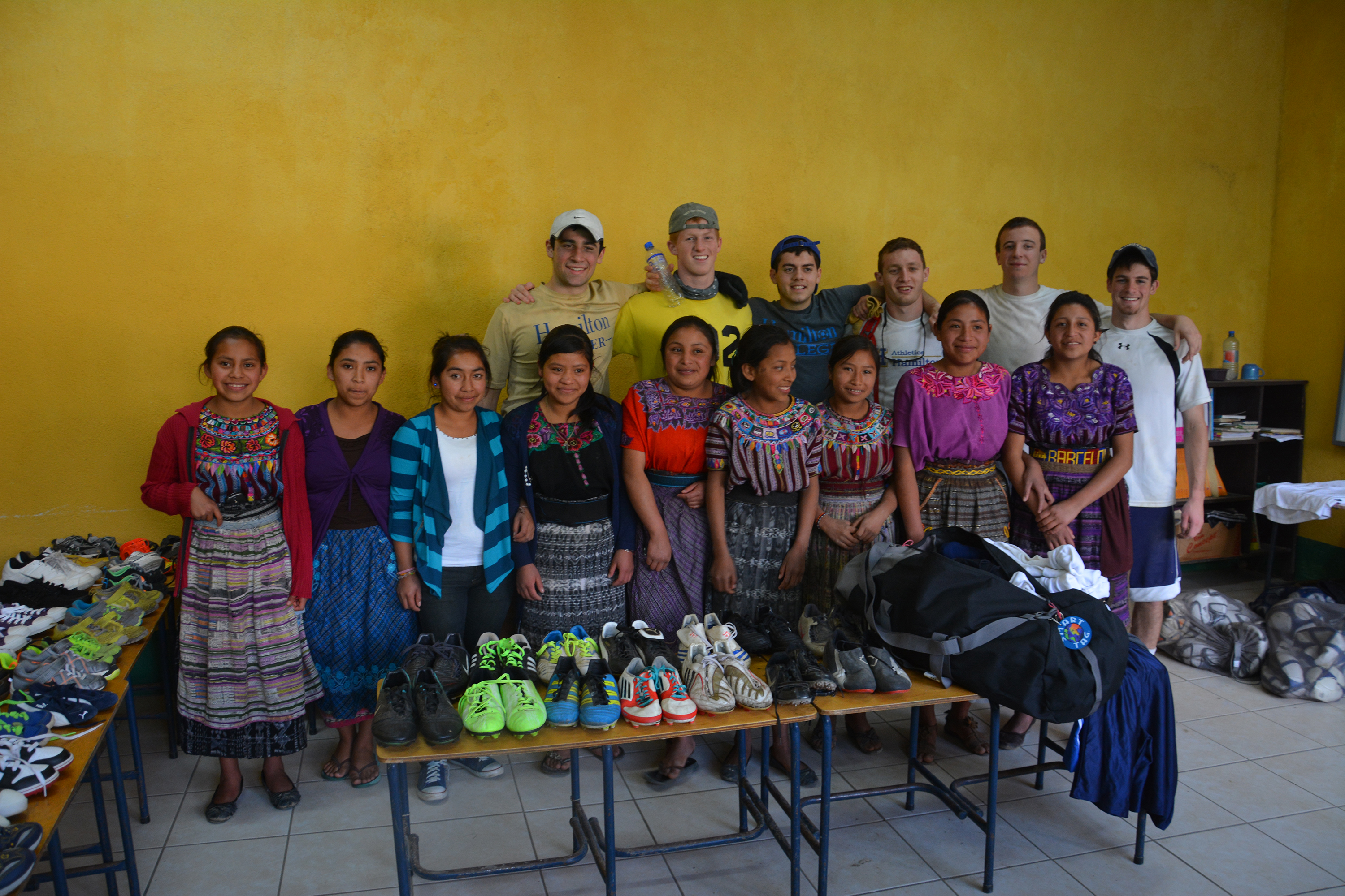 Hamilton soccer team members with with the village's women's soccer team. The women practiced and played in bare feet before the Hamilton teammates brought them the cleats. 