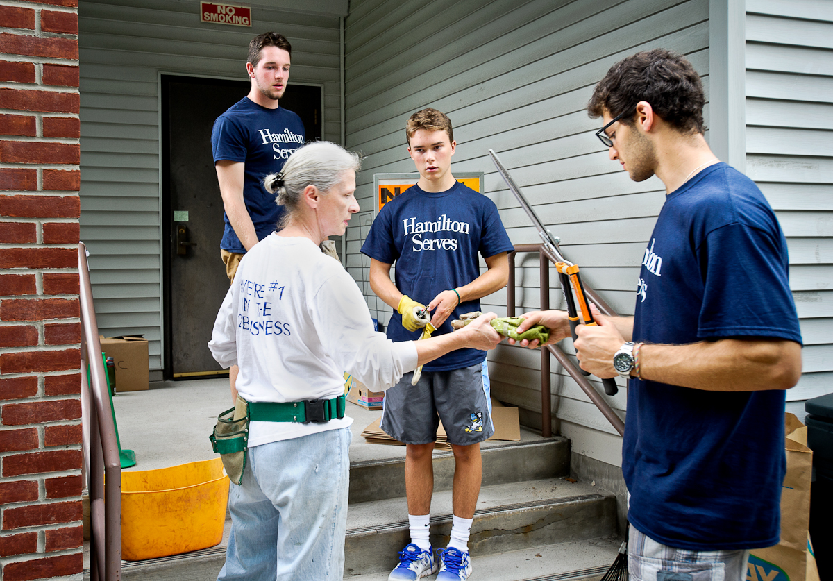 Dan Horgan '18 (left), Michael Mac Bolder' Houghton '18, and Jared Mandelbaum '18 accept supplies from Kris Bellona as they volunteer at Kirkland Town Library.