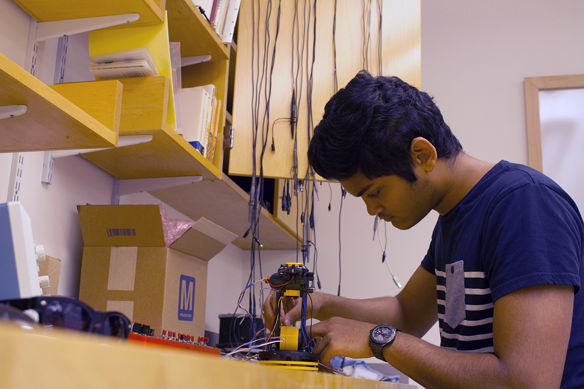 Steve Laurent Cunden '18 works on a robotic arm.