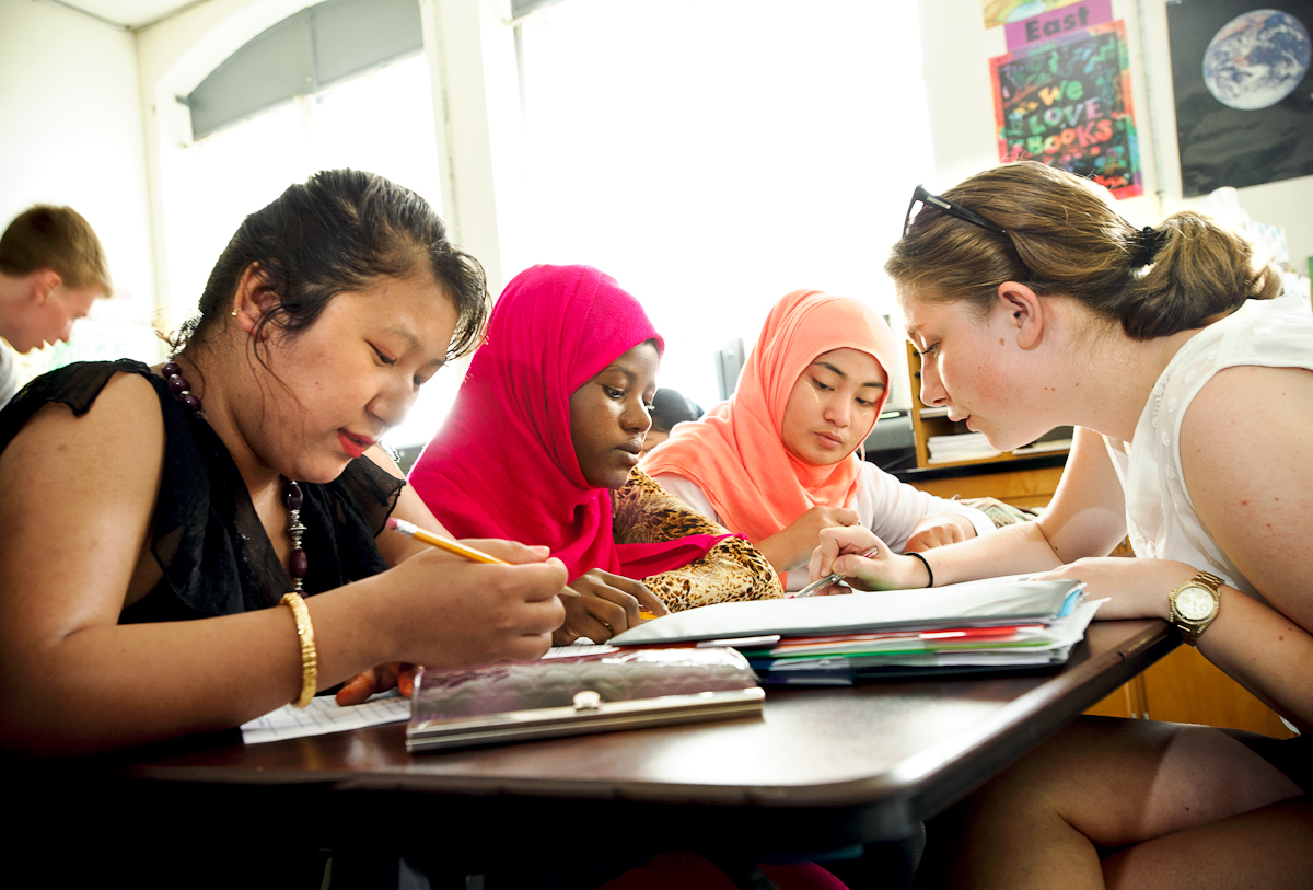 From left Sak Maya Rai, Asha Ahmed, and Cho Cho Win get a reading lesson from Hamilton alumna Sidika Kajtezovic '14,