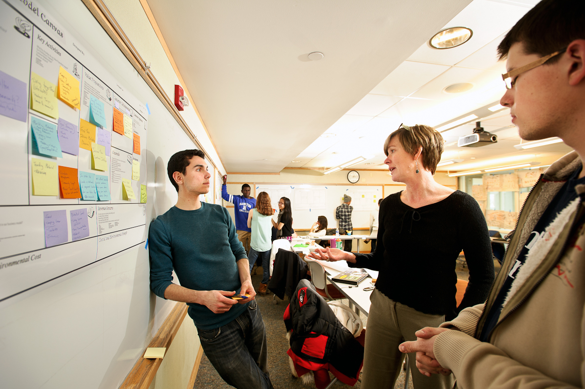 Michael Nelson '16 left, and Alexandru Hirsu '17 speak with Anke Wessels, of Cornell University, center, as they work on a project together during the Levitt Social Innovation Fellows Program.