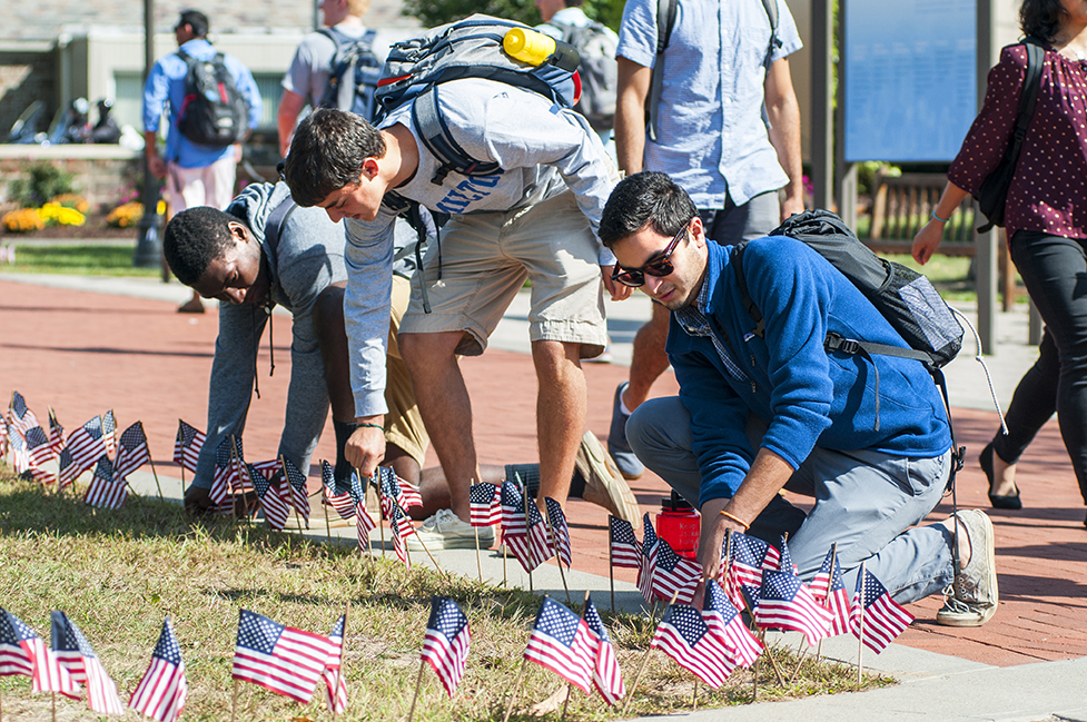 Students place flags along Martin's Way.