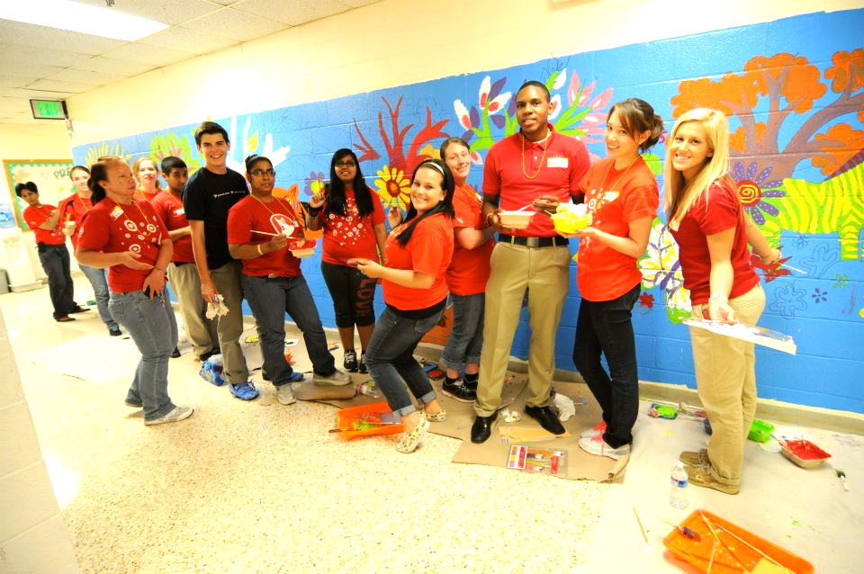 Jose Vazquez '15 (blue shirt) paints a mural at a school in Baltimore with his group.
