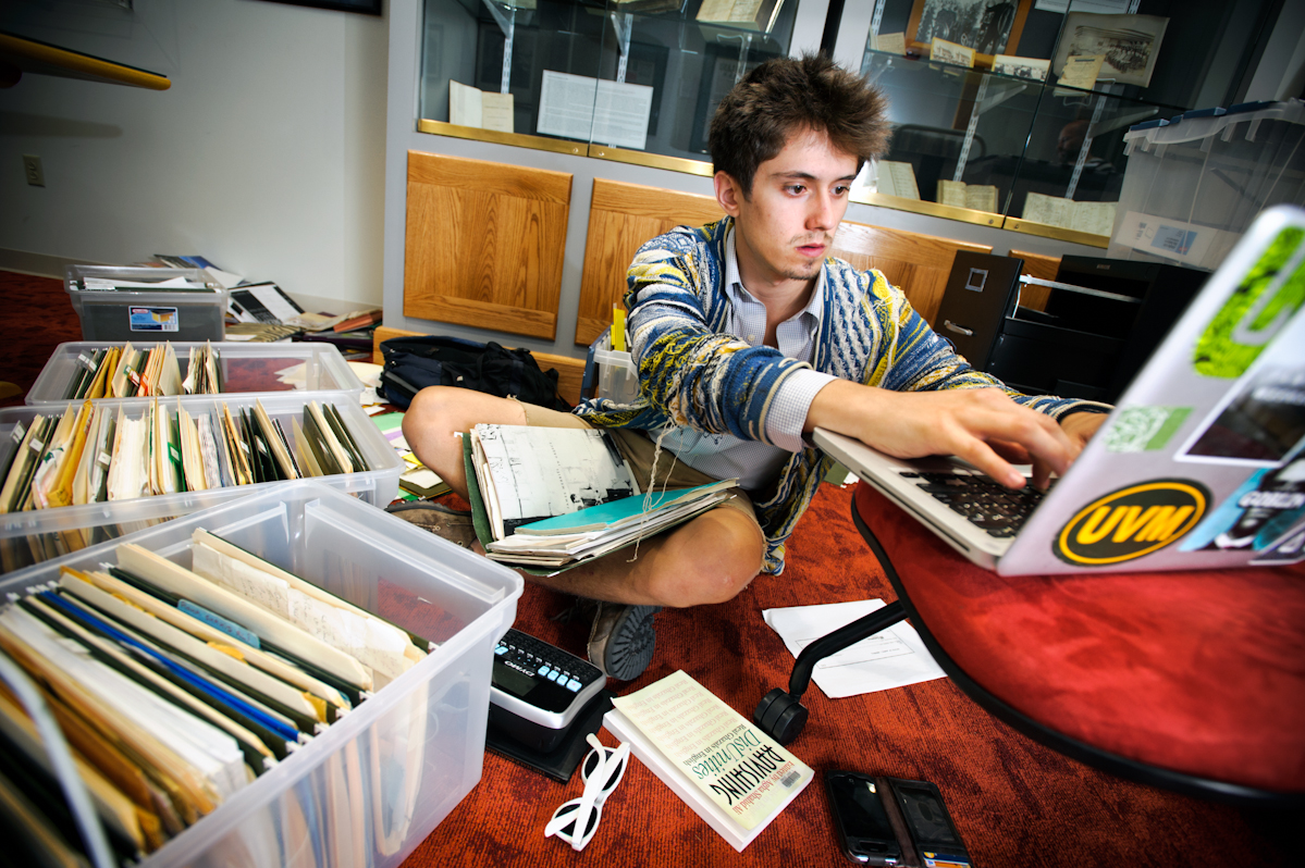 Will Newman '14 sorts and organizes a large cache of materials by the late poet Agha Shahid Ali in Burke Library's Special Collections.