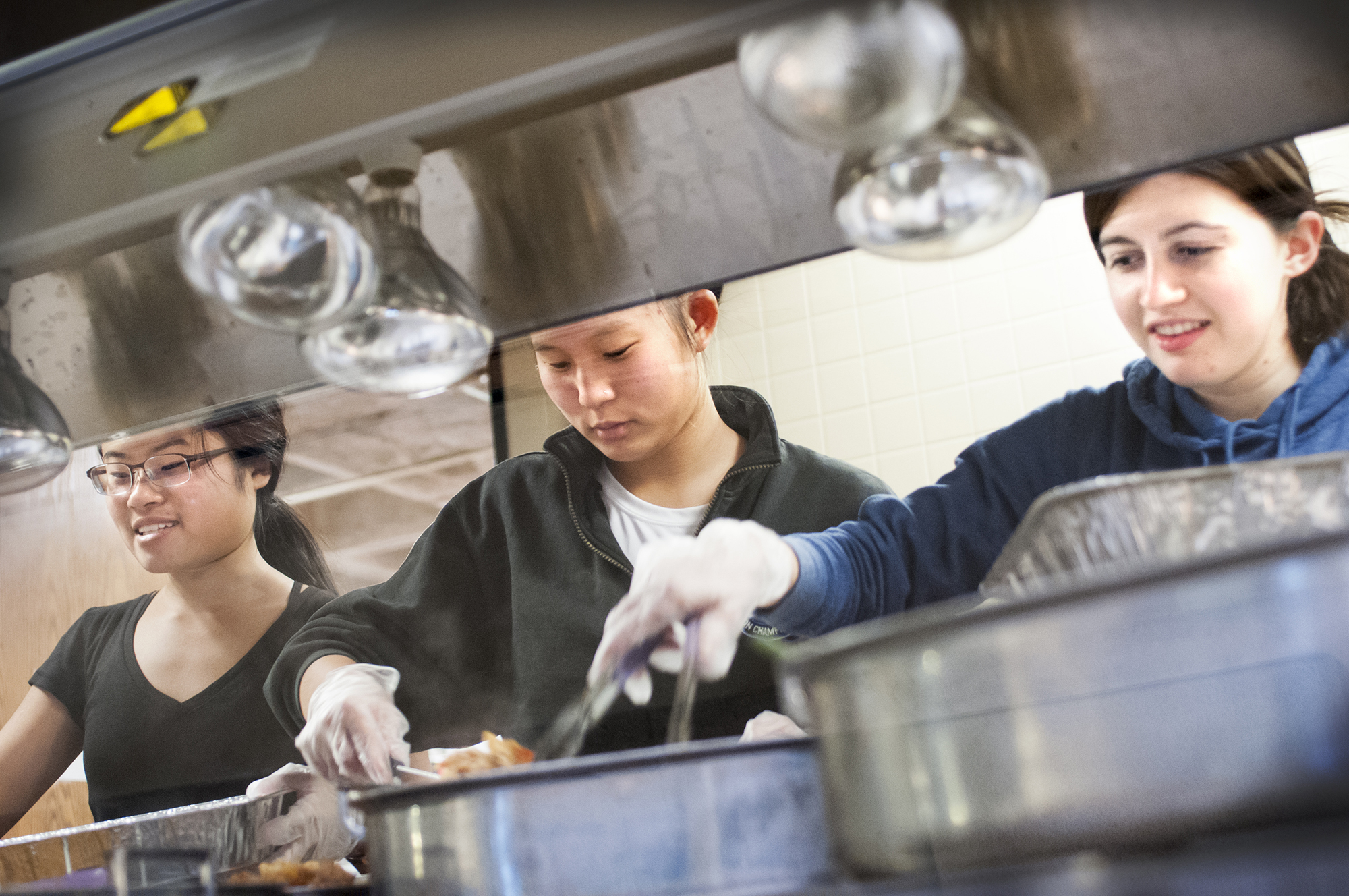 Harvest volunteers Emily Yong '19, Molly Clark '19 and Caitlin Anthony '19 pack food in McEwen.